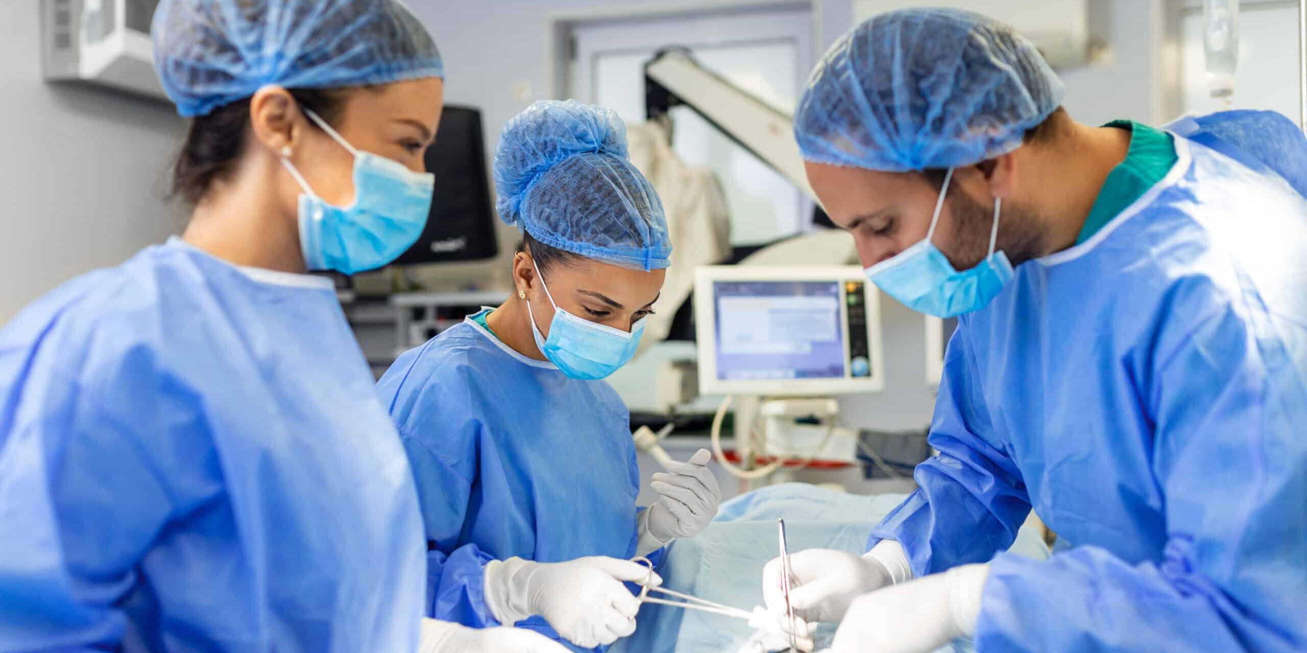 Group of surgeons doing surgery in hospital operating theater. Medical team doing critical operation. Group of surgeons in operating room with surgery equipment. Modern medical background